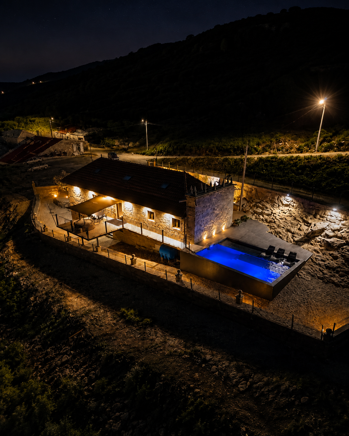 Vista aérea noturna da Fagundes Village com piscina iluminada